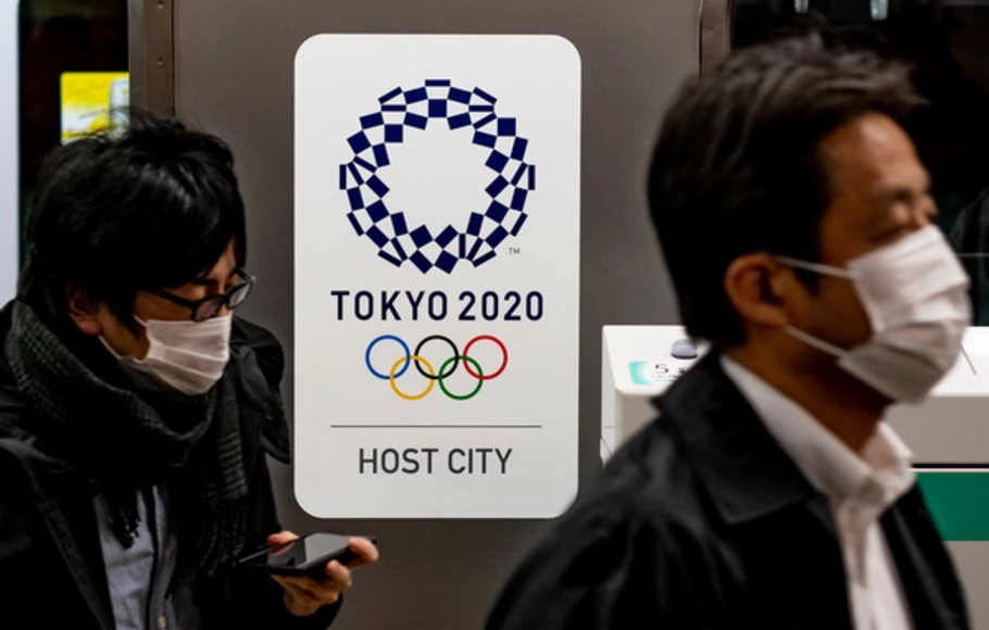 Poster pertandingan Olimpiade Tokyo 2020 terlihat saat para penumpang turun dari kereta api di Tokyo, Jepang, Senin (30/11/2020.