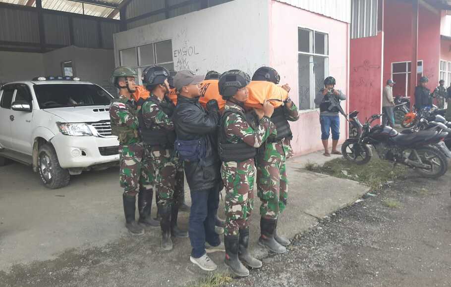 Prajurit TNI menggotong jenazah anggota Yonif 400/BR Prada Agus Kurniawan, yang meninggal dalam kontak senjata dengan kelompok kriminal bersenjata di Titigi, Kabupaten Intan Jaya, Papua, Minggu, 10 Januari 2021.