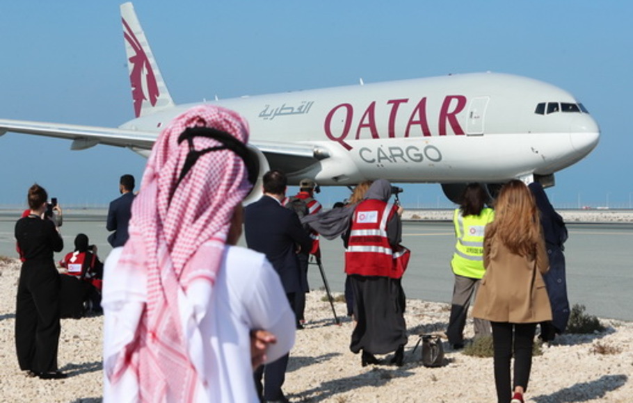 Para wartawan berkumpul di dekat pesawat Qatar Airways di landasan Bandara Internasional Hamad dekat ibu kota Qatar, Doha, saat penerbangan komersial pertama ke Arab Saudi akan lepas landas, Senin (11/1/2021).