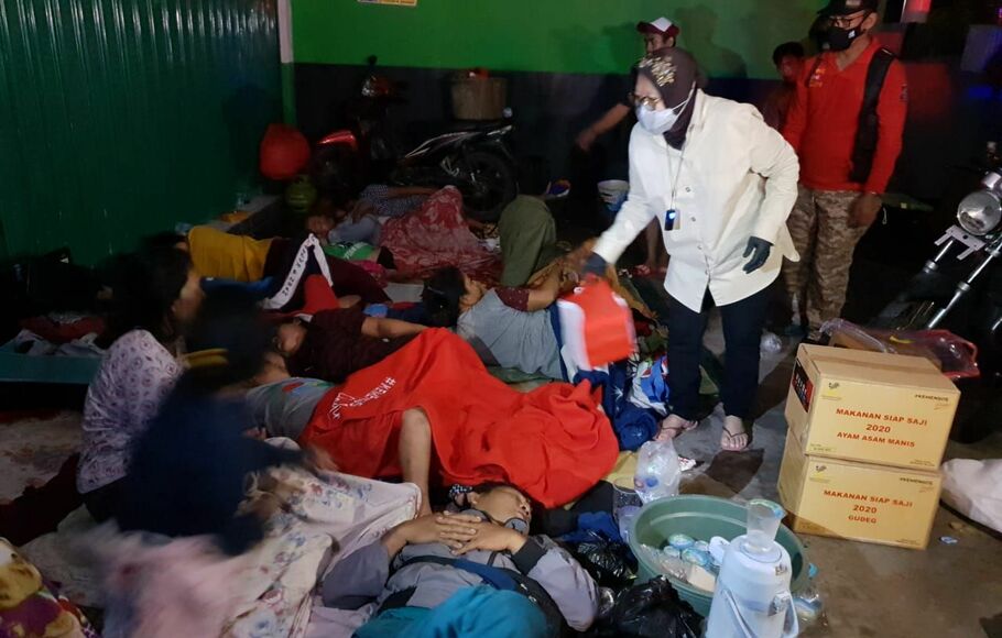 Mensos Tri Rismaharini berbincang dengan salah seorang pengungsi  banjir di Kecamatan Pebayuran, Kabupaten Bekasi, seusai memberikan bantuan, Senin, 22 Februari 2021 dini hari. 