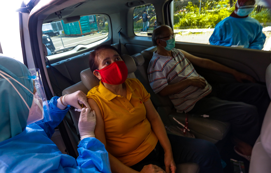 Vaksinator menyuntikan vaksin Covid-19 di pos pelayanan vaksinasi drive thru Halodoc di kawasan Kemayoran, Jakarta, Rabu, 3 Maret 2021.