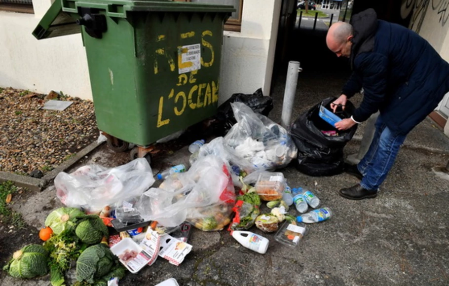 Seorang juru sita Prancis mencatat sampah makanan di tempat sampah supermaket di Mimizan-Plage, barat daya Prancis, Kamis (4/3/2021). Sekitar 17% makanan yang tersedia untuk konsumen di seluruh dunia pada tahun 2019 - hampir satu miliar ton - dibuang oleh rumah tangga, pengecer, institusi, dan industri perhotelan.