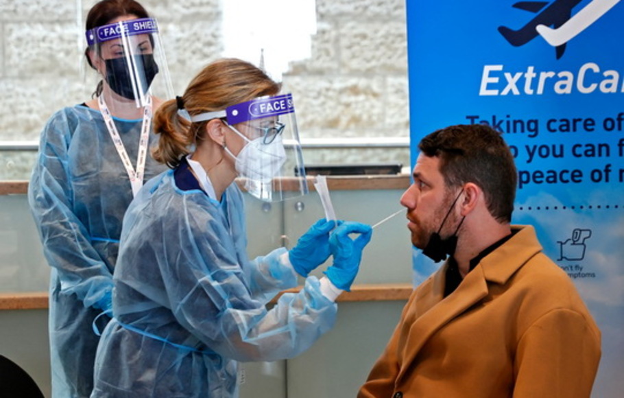 Seorang anggota staf medis memperlihatkan prosedur baru, yang akan diterapkan pada penumpang penerbangan yang akan datang ke New York, di Bandara Ben Gurion Israel dekat Tel Aviv, Senin (8/3/2021).