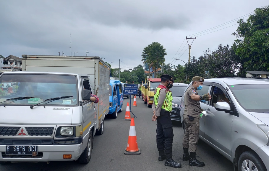 Petugas gabungan melakukan penjaringan kendaraan dalam razia protokol kesehatan  di Simpang Gadog, Kamis 11 Maret 2021.