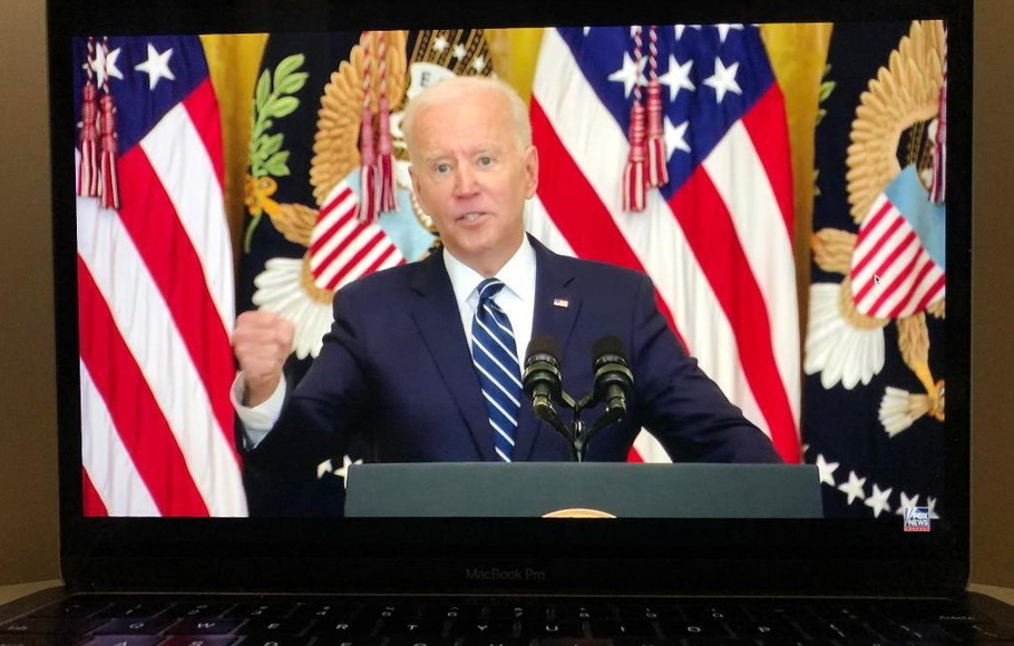 Layar laptop menampilkan Presiden AS Joe Biden berbicara selama konferensi pers di Washington, D.C, Kamis 25 Maret 2021 dalam siaran langsung yang disediakan oleh Fox News.
