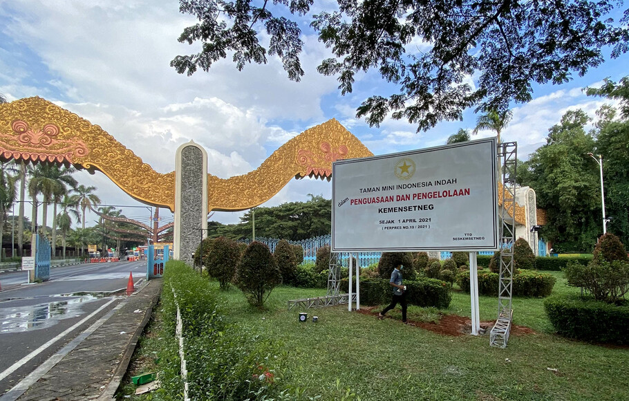Pekerja menyelesaikan pemasangan papan pengumuman tentang pengambilalihan pengelolaan Taman Mini Indonesia Indah (TMII) di depan pintu masuk TMII, Jakarta Timur, Rabu, 7 April 2021. 