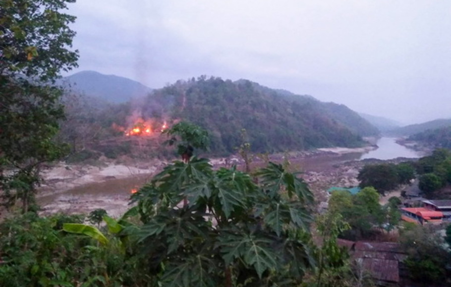 Kebakaran terjadi di pangkalan militer Myanmar di sepanjang tepi sungai Salween, seperti terlihat dari kota Mae Sam Laep di provinsi Mae Hong Son Thailand, pada Selasa 27 April 2021, setelah pangkalan itu diserang dan direbut pemberontak Persatuan Nasional Karen (KNU).