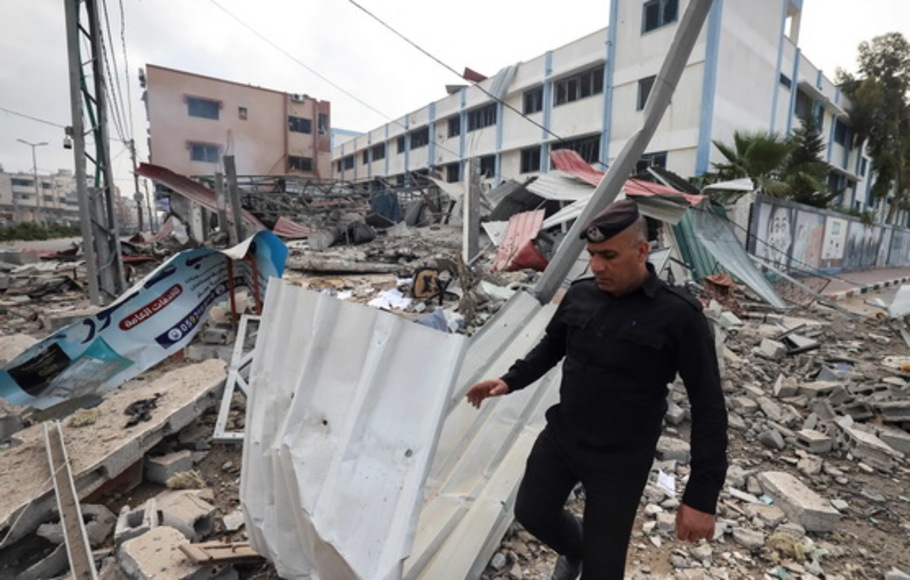 Seorang petugas polisi Palestina memeriksa puing-puing bangunan keamanan yang dihancurkan oleh serangan udara Israel di Gaza pada Selasa 11 Mei 2021. 