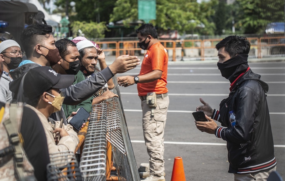 Petugas memberikan imbauan kepada warga yang akan berwisata untuk kembali pulang di depan pintu masuk Ancol Taman Impian, Jakarta, Sabtu, 15 Mei 2021.