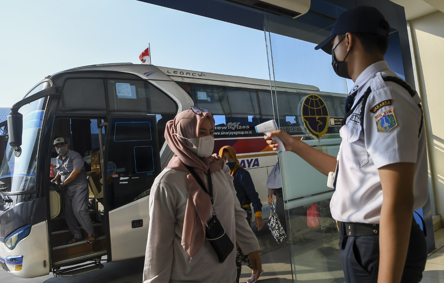 Petugas memeriksa suhu tubuh dari pemudik saat tiba di Terminal Terpadu Pulo Gebang, Jakarta Timur, Sabtu, 15 Mei 2021.