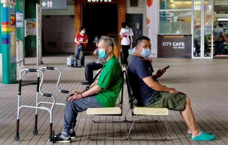 Penduduk lokal, yang mengenakan masker wajah setelah Taiwan meningkatkan tingkat kewaspadaannya di beberapa lokasi setelah gelombang baru infeksi virus corona Covid-19, menunggu bus di Bitan - tempat pemandangan populer - di New Taipei City, Taiwan pada Sabtu 15 Mei 2021.