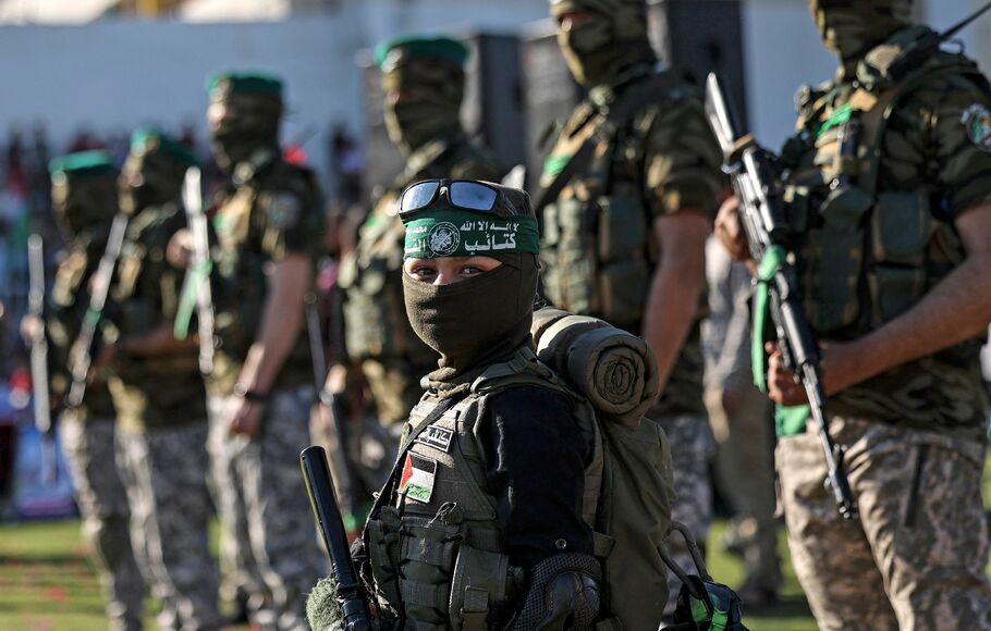 Seorang bocah laki-laki ikut berbaris bersama para anggota Brigade Al-Qassam, sayap militer kelompok Hamas, dalam pawai di Gaza City pada 24 Mei 2021.