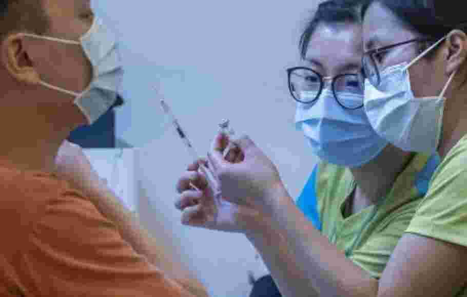 Petugas kesehatan memeriksa botol saat memberikan dosis vaksin Sinovac buatan Tiongkok di Hong Kong. 