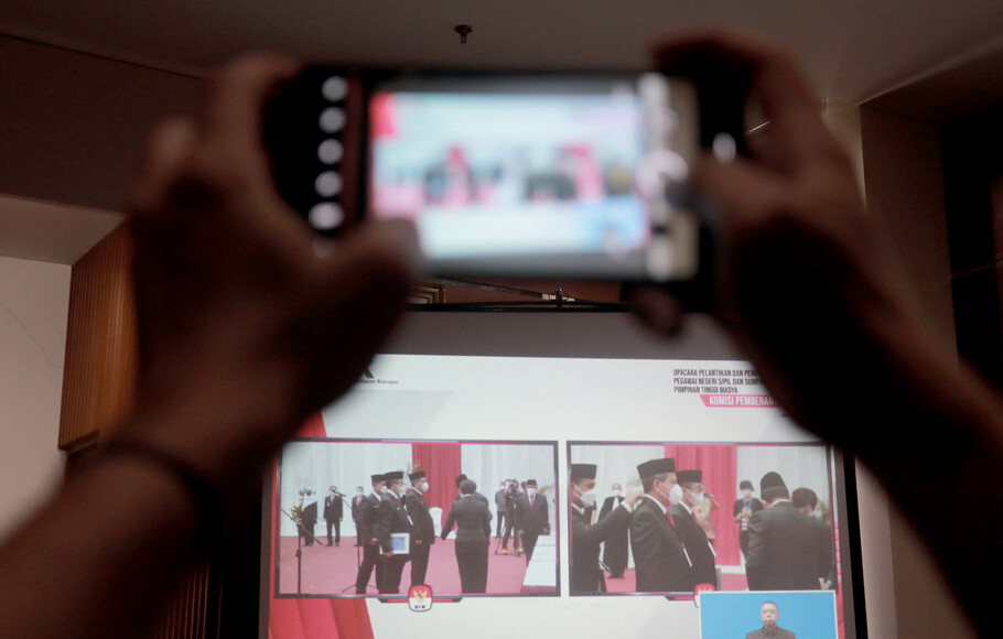 Pewarta memotret layar yang menampilkan prosesi pelantikan pegawai KPK menjadi Aparatur Sipil Negara (ASN) di gedung KPK, Jakarta, Selasa 1 Juni 2021.
