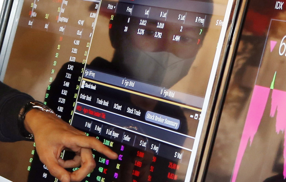 Pialang melihat pergerakan harga saham melalui layar monitor di salah satu sekuritas di Jakarta. 