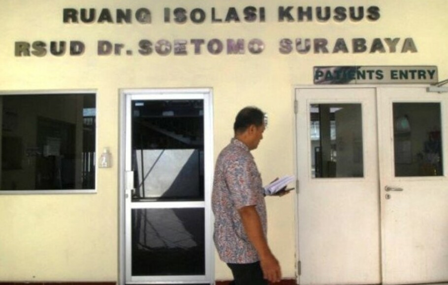 Petugas melintas di depan pintu masuk Ruang Isolasi Khusus (RIK) RSUD Soetomo, Surabaya, Jawa Timur.  