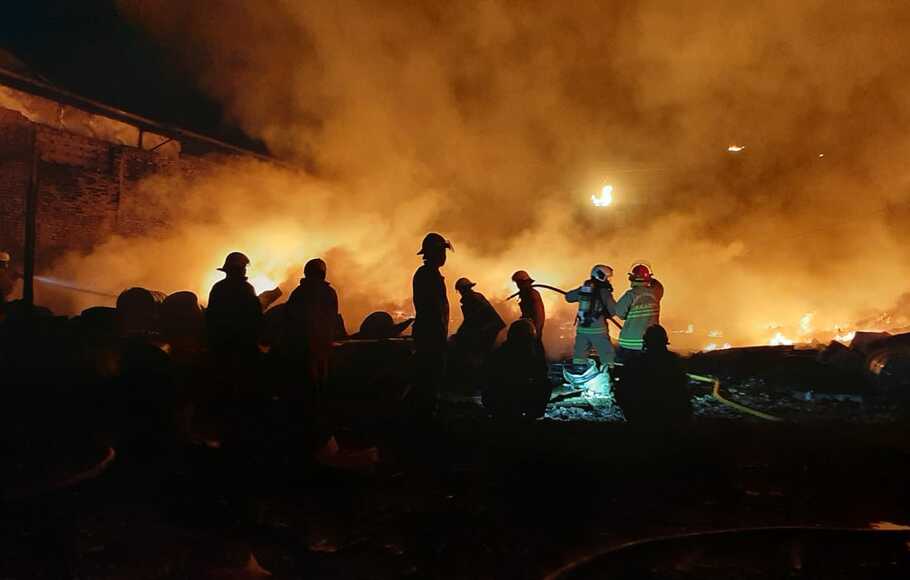 Petugas berupaya memadamkan api yang membakar gudang biji plastik, di Tegal Alur, Kalideres, Jakarta Barat. 