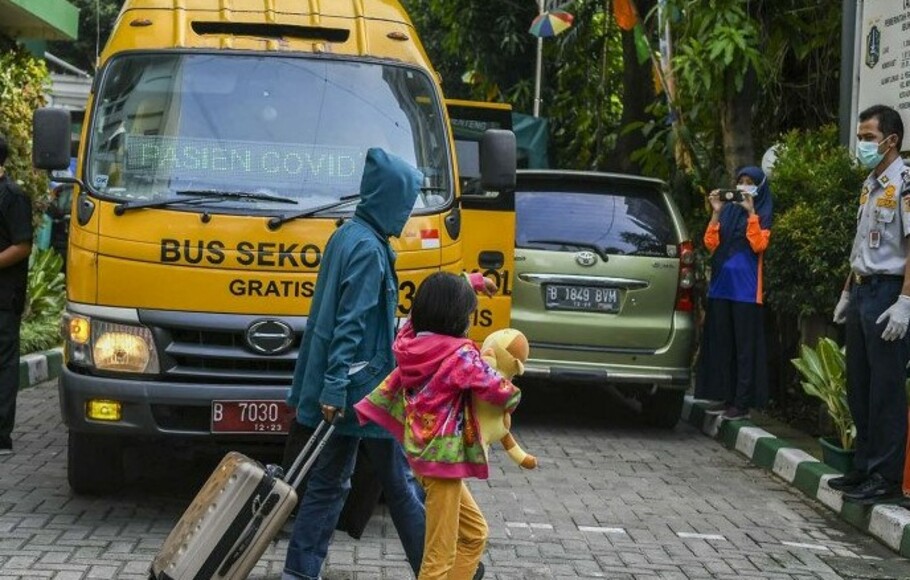 Pasien Covid-19 memasuki bus sekolah untuk menuju Rumah Sakit Darurat Covid (RSDC) Wisma Atlet Kemayoran di Puskesmas Menteng, Jakarta, Minggu 20 Juni 2021). 