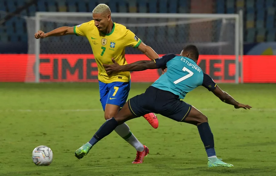 Penyerang Brasil, Richarlison (kiri) mencoba melewati adangan pemain Ekuador Pervis Estupinan.
