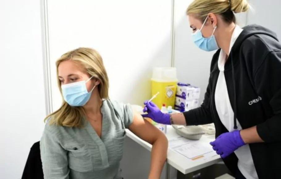 Seorang dokter memvaksinasi karyawan dengan vaksin Pfizer BioNTech di pusat vaksinasi di Leverkusen, Jerman barat. 