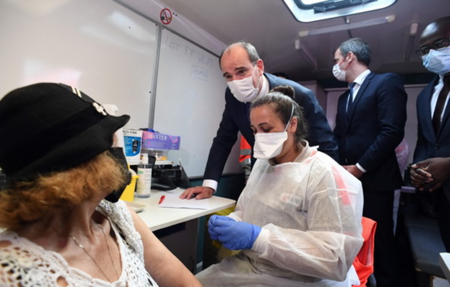 Perdana Menteri Prancis Jean Castex (kiri), di sebelah Menteri Kesehatan Prancis Olivier Veran (kedua kanan), berbicara kepada seorang wanita sebelum dia menerima dosis vaksin Covid-19 Pfizer-BioNTech di pusat vaksinasi di Villetaneuse, pinggiran utara Paris, pada Selasa 27 Juli 2021. 