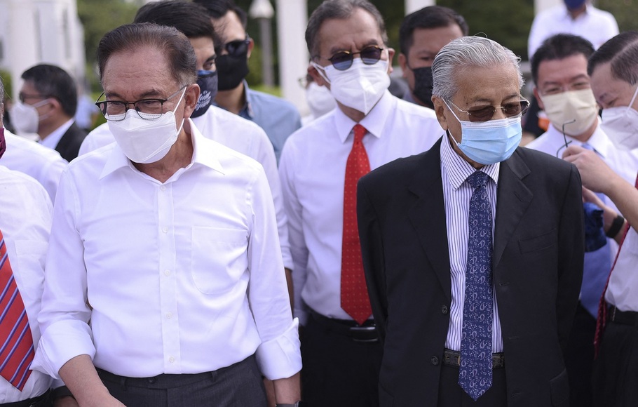 Mantan Perdana Menteri Malaysia Mahathir Mohamad (kanan) dan anggota parlemen oposisi Anwar Ibrahim (kiri) berbaris di depan sebagai protes di depan gedung parlemen yang ditutup di Kuala Lumpur pada 2 Agustus 2021. 