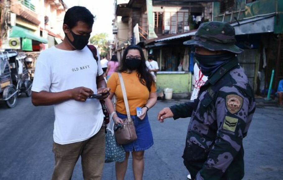 Aparat keamanan  memeriksa identifikasi warga saat karantina wilayah terkait Covid-19  diberlakukan di Navotas, pinggiran kota Manila, Filipina, Kamis 16 Juli 2021. 