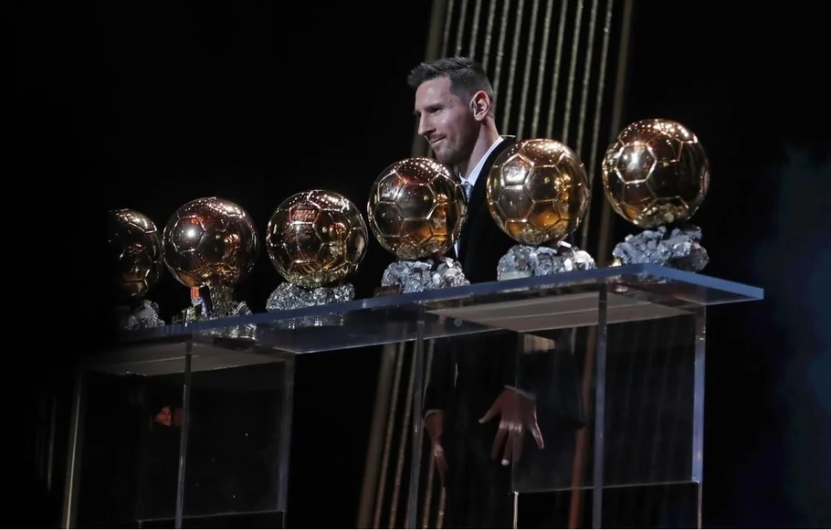 Lionel Messi dan trofi Ballon d'Or yang telah dia raih.