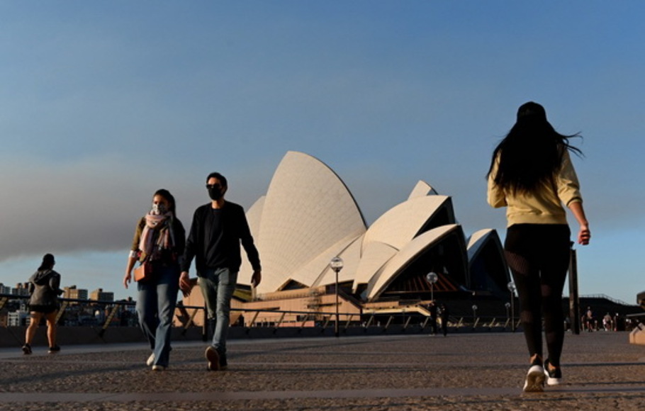 Orang-orang berjalan di dekat Opera House di Sydney pada Sabtu 14 Agustus 2021, ketika kota terbesar Australia mengumumkan pembatasan Covid yang lebih ketat termasuk denda yang lebih berat dan pengawasan yang lebih ketat untuk meredam varian Delta. 