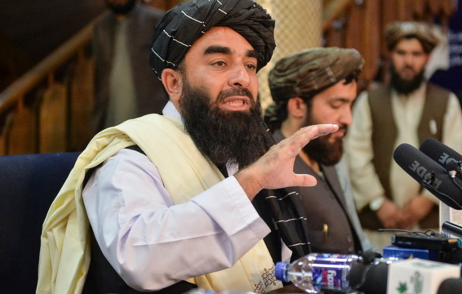 Juru bicara Taliban Zabihullah Mujahid (kiri) memberi isyarat saat dia berbicara selama konferensi pers pertama di Kabul, Afghanistan pada Selasa 17 Agustus 2021 setelah pengambilalihan Afghanistan yang mengejutkan oleh Taliban. 