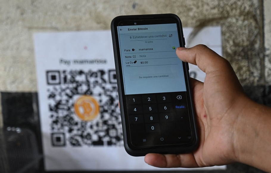 Seorang pria menggunakan aplikasi bitcoin di sebuah toko di El Zonte, La Libertad, El Salvador pada 4 September 2021. Kongres El Salvador menyetujui pada bulan Juni sebuah undang-undang yang akan membuat tender legal bitcoin di negara itu mulai 7 September.