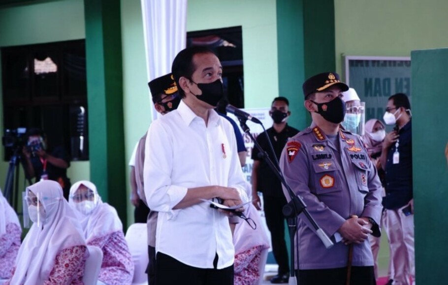 Kapolri Jenderal Pol Listyo Sigit Prabowo (kanan) mendampingi Presiden Joko Widodo meninjau pelaksanaan Vaksinasi Merdeka di Pondok Pesantren KH Syamsudin, Ponorogo, Jawa Timur, Selasa 7 September 2021. 
