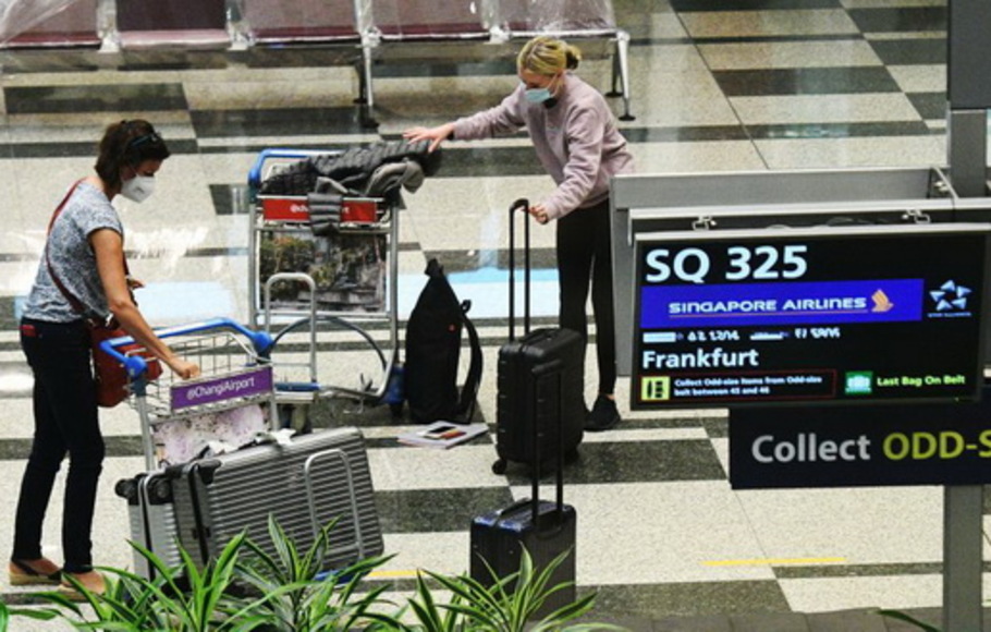 Para pelancong dengan penerbangan Singapore Airlines SQ325 mengambil bagasi di ruang bagasi di Bandara Changi, Singapura pada Rabu 8 September 2021. 