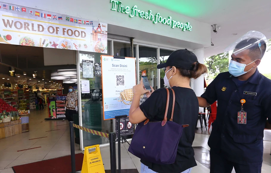 Warga memindai kode batang PeduliLindungi sebelum berbelanja di Hero Supermarket di Bintaro, Tangerang Selatan, Banten, Selasa, 14 September 2021. Masyarakat yang ingin berbelanja ke supermarket, mulai hari ini harus menggunakan aplikasi PeduliLindungi.