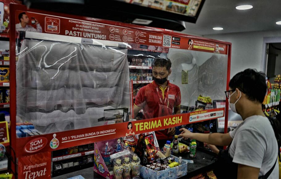 Suasana kasir yang menutup stiker, poster, dan pajangan produk rokok di sebuah mini market di kawasan Jakarta Barat, Selasa 14 September 2021.