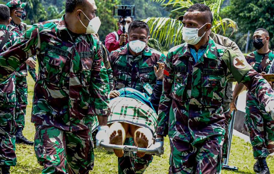 Tenaga kesehatan Puskesmas Kiwirok, Kabupaten Pegunungan Bintang, Papua, yang menjadi korban penyerangan KKB ditandu personel TNI AD, Jumat, 17 September 2021. 