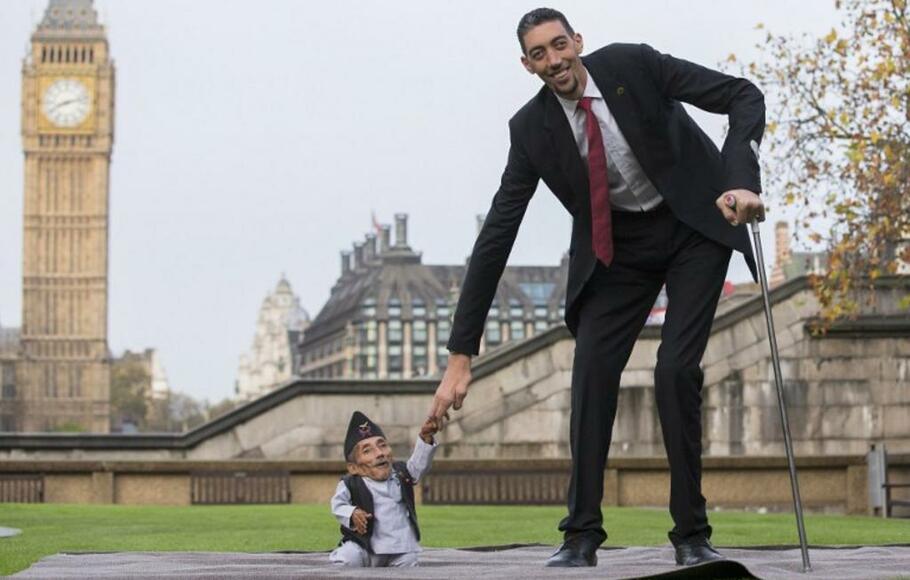 Chandra Bahadur Dangi, dari Nepal, (kiri) orang dewasa terpendek di dunia, berfoto dengan pria tertinggi di dunia Sultan Kosen dari Turki, saat sesi pemotretan di London, Inggris pada 13 November 2014. 