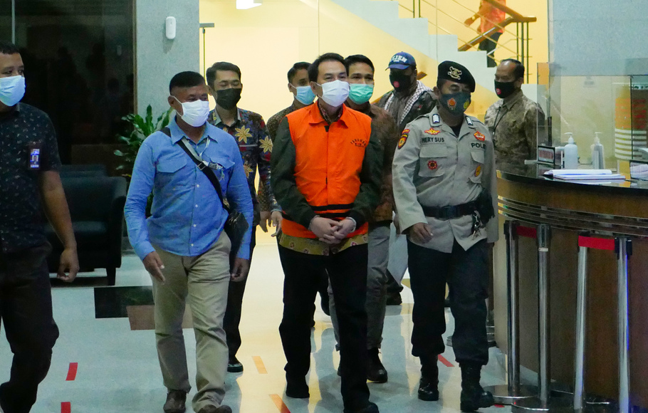 Wakil Ketua DPR, Azis Syamsuddin mengenakan rompi oranye dan diborgol dalam kawalan petugas di Gedung KPK, Jakarta, Sabtu 25 September 2021 dini hari.
