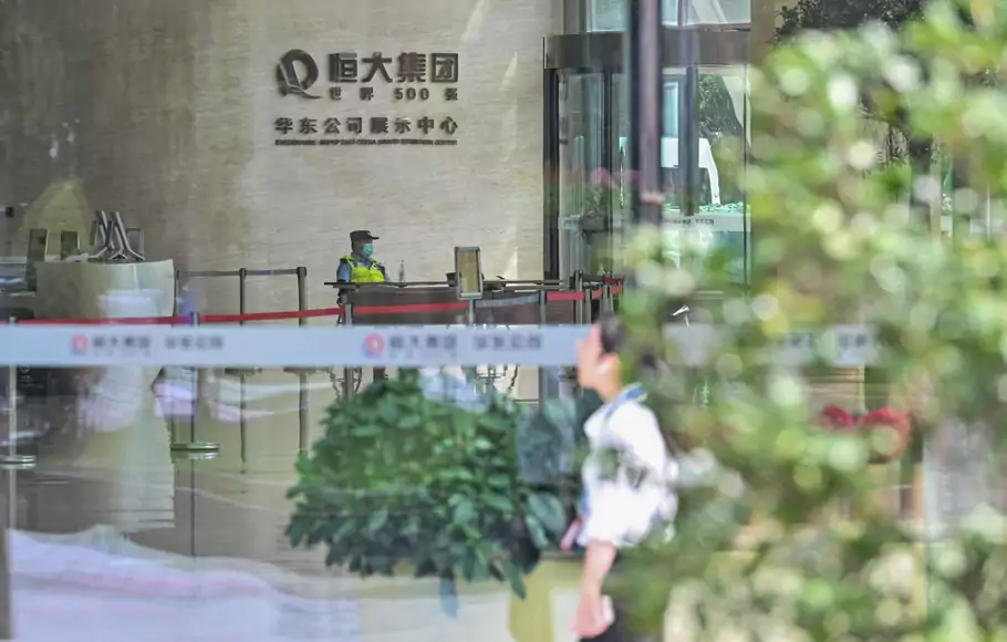 Seorang polisi terlihat di gedung Evergrande Center di Shanghai, Tiongkok, pada 24 September 2021.