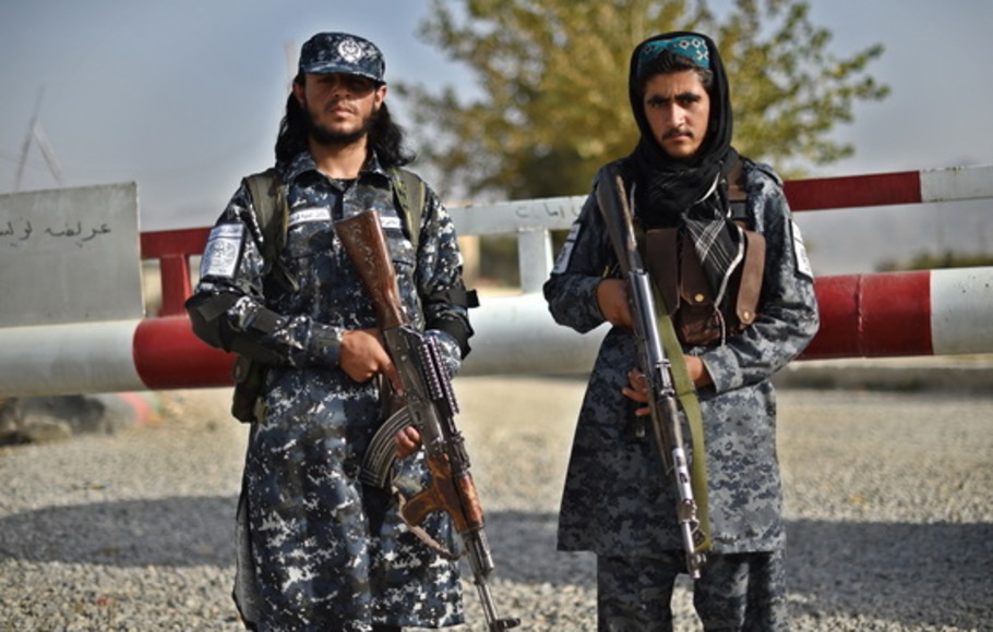 Para tentara Taliban yang bekerja sebagai polisi berjaga di gerbang masuk sebuah distrik polisi di Kabul, Afghanistan, Minggu 3 Oktober 2021. 