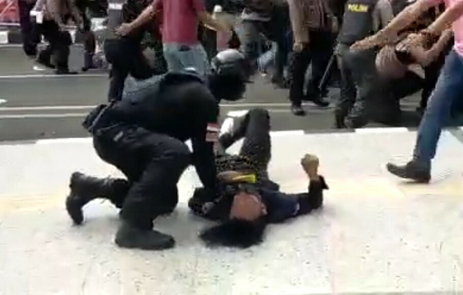 Seorang polisi membanting keras mahasiswa saat demo di Kabupaten Tangerang, Rabu 13 Oktober 2021.