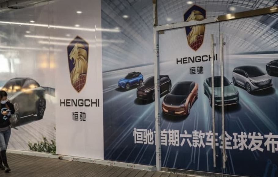 Seorang pejalan kaki melewati toko mobil listrik Evergrande yang belum dibuka di Wuhan, provinsi Hubei, Tiongkok. 

