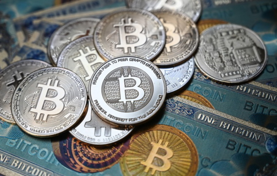 Foto ilustrasi pada 19 Juli 2021 di Istanbul menunjukkan uang kertas fisik dan koin tiruan dari mata uang kripto Bitcoin. Bitcoin menembus angka US$ 60.000 untuk pertama kalinya sejak April pada 15 Oktober 2021.