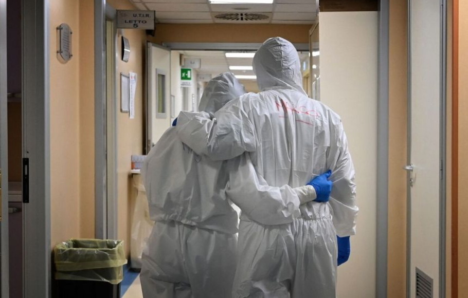 Petugas kesehatan yang mengenakan alat pelindung mengakhiri kerja shift mereka di koridor unit perawatan intensif tingkat di rumah sakit San Filippo Neri di Roma, Italia.