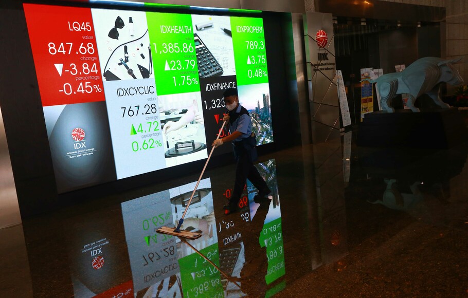 Petugas kebersihan beraktivitas di depan layar elektronik Bursa Efek Indonesia (BEI) di Jakarta.