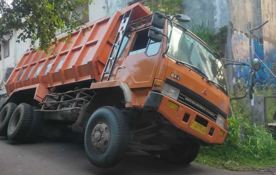Truk fuso bernomor polisi A 9129 ZA bermuatan batu nyasar dan terperosok di jalan sempit Panaragan Kidul, Kelurahan Panaragan, Kecamatan Bogor Tengah, Kota Bogor, Minggu, 31 Oktober 2021.