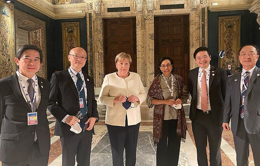 Menteri Keuangan Indonesia Sri Mulyani (ketiga, kanan) berfoto bersama kanselir Jerman Angela Merkel (ketiga, kiri) dan menteri keuangan negara G20 di sela-sela pertemuan G20 di Roma, Sabtu, 30 Oktober 2021.