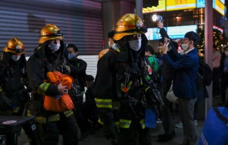 Petugas pemadam kebakaran keluar dari Stasiun Kokuryo di Jalur Keio di kota Chofu di Tokyo barat, Jepang pada Minggu 31 Oktober 2021, setelah serangan pisau dan api oleh seorang pria di kereta. 