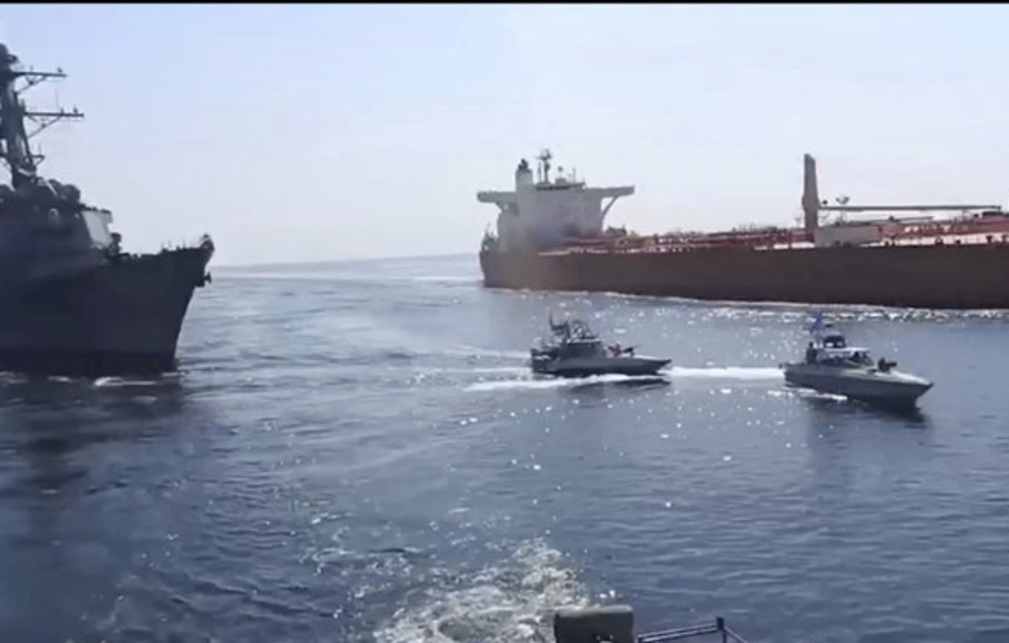Kapal cepat Pengawal Revolusi paramiliter Iran (tengah) berada di depan kapal perang AS (kiri), di tengah penyitaan satu kapal tanker minyak berbendera Vietnam (kanan) di Teluk Oman.