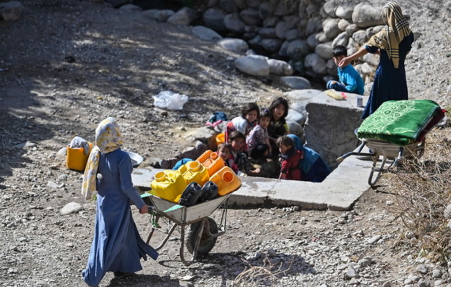 Seorang wanita Afghanistan membawa kereta dorong saat pergi mengambil air  di satu desa distrik Qarabagh yang berjarak 56 km di barat daya Ghazni, di provinsi Ghazni, Afghanistan pada 14 November 2021. 